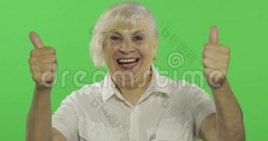 一位老妇人竖起大拇指，微笑着。 <strong>老奶奶</strong>。 铬键